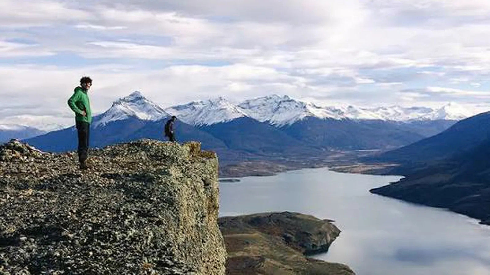 Caminantes recorren una costa austral de piedras cerca de Puerto Natales.