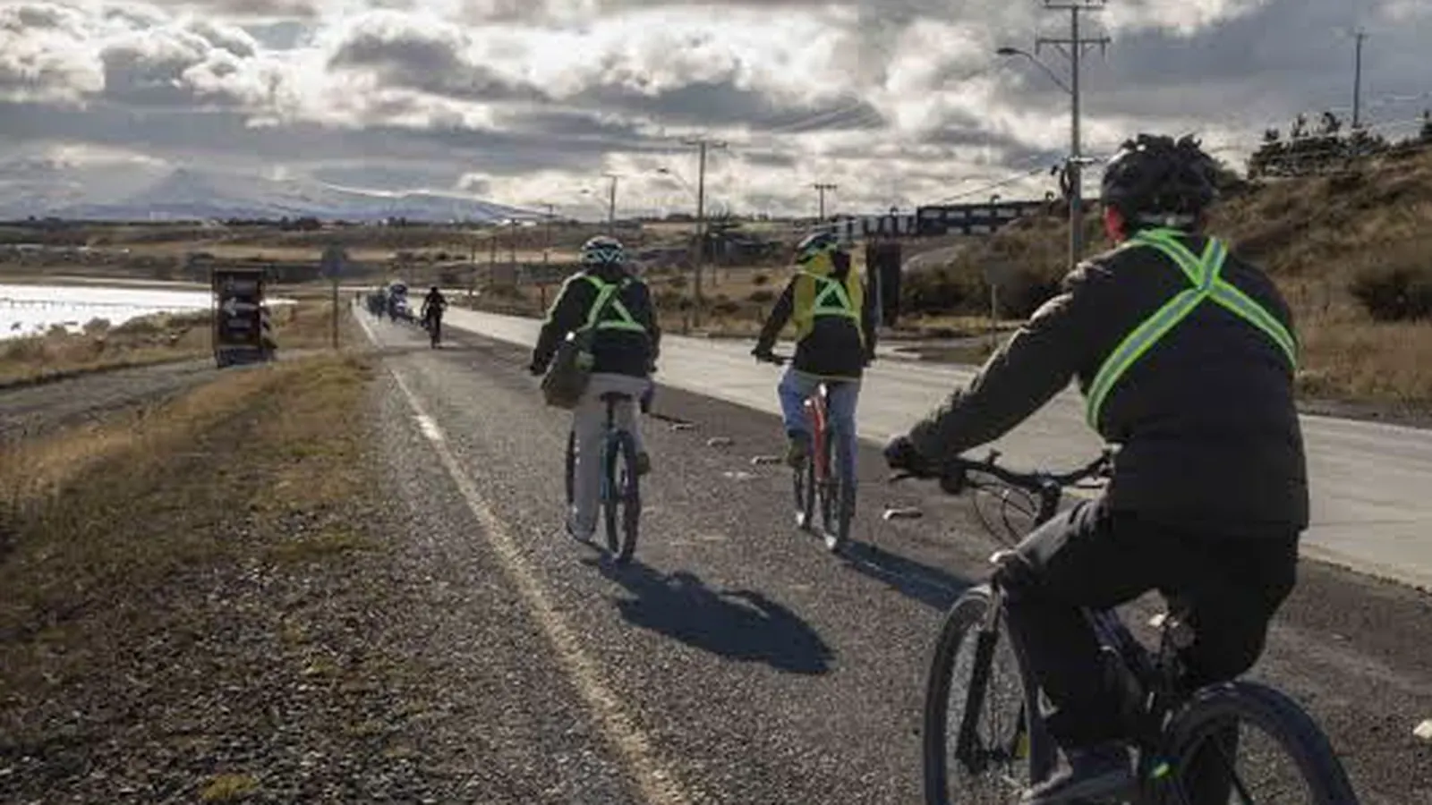 Ciclista con casco recorre una vía de ripio en el entorno de Puerto Natales.